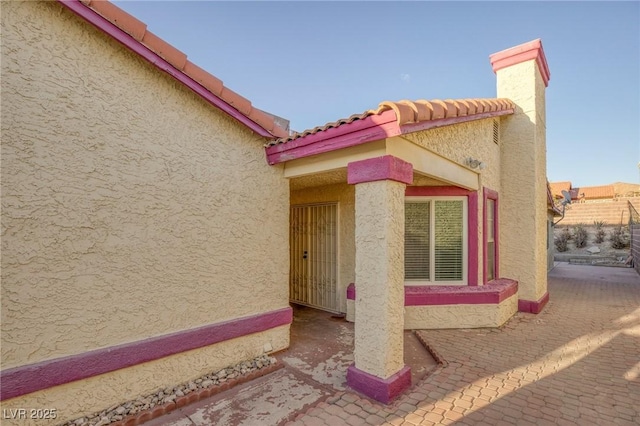 view of property exterior featuring stucco siding and a tile roof
