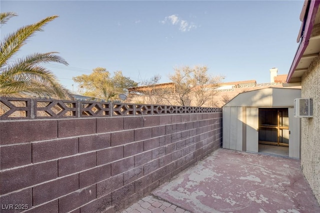 view of patio / terrace featuring fence and a storage unit