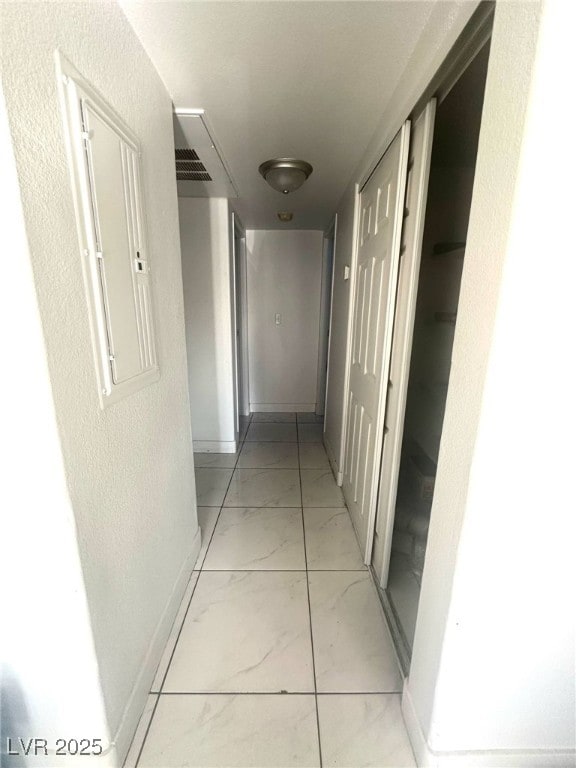 hall with baseboards and marble finish floor