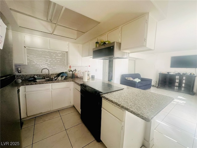 kitchen featuring decorative backsplash, a peninsula, open floor plan, a sink, and exhaust hood