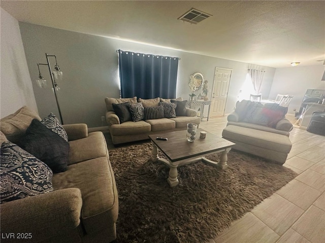 living area featuring visible vents, wood tiled floor, and baseboards