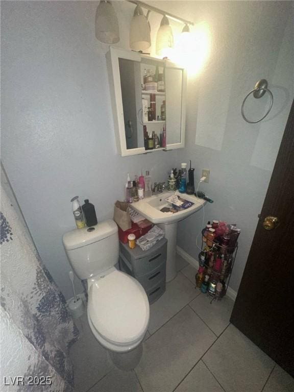 half bathroom with tile patterned flooring and toilet