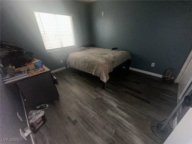 bedroom featuring baseboards and dark wood-style flooring