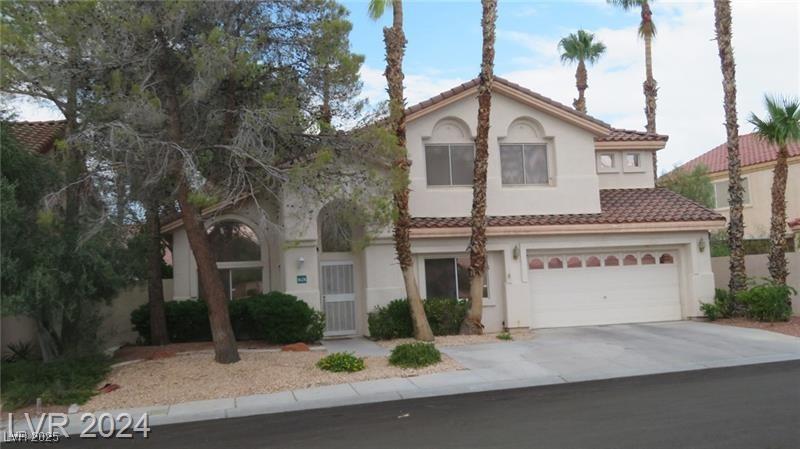 mediterranean / spanish home featuring a garage, stucco siding, concrete driveway, and a tiled roof
