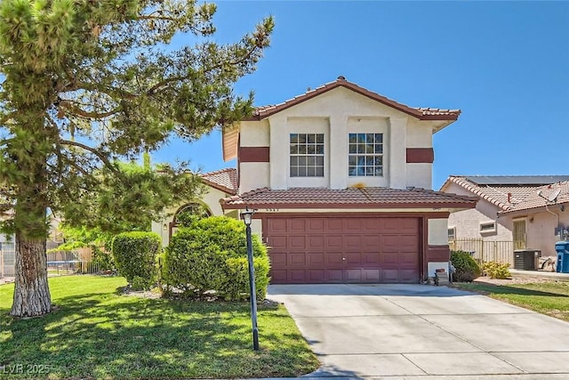 mediterranean / spanish home featuring stucco siding, an attached garage, and a tile roof