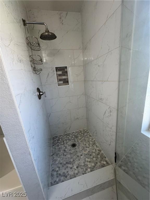 bathroom featuring a tile shower