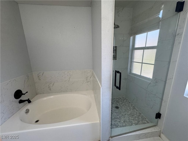 bathroom with a shower stall and a bath
