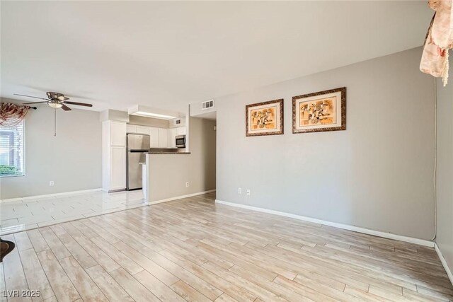 4955 Lindell Rd Unit 130, Las Vegas, NV 89118 - unfurnished living room with ceiling fan, light wood-type flooring, and baseboards