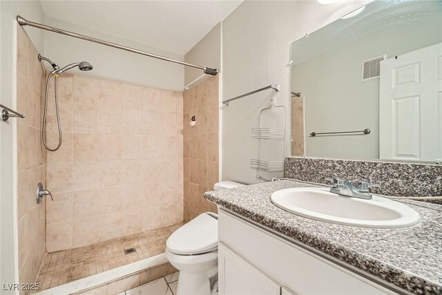4955 Lindell Rd Unit 130, Las Vegas, NV 89118 - full bathroom featuring toilet, vanity, a tile shower, and tile patterned floors
