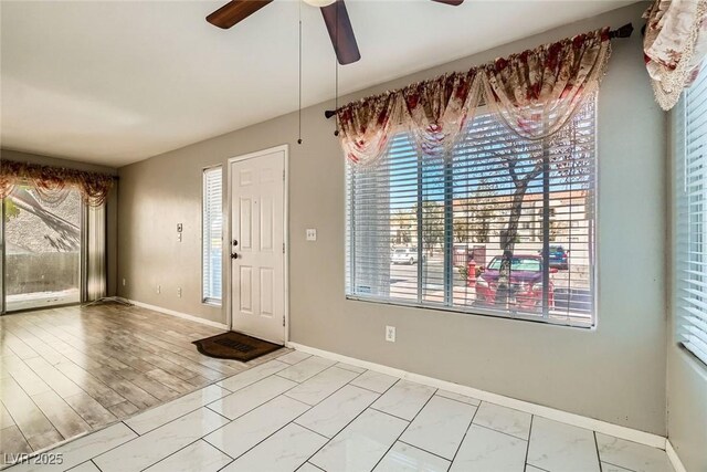 4955 Lindell Rd Unit 130, Las Vegas, NV 89118 - entryway with marble look tiles, a ceiling fan, healthy amount of natural light, and baseboards