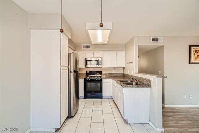 4955 Lindell Rd Unit 130, Las Vegas, NV 89118 - kitchen featuring stainless steel appliances, a sink, white cabinets, baseboards, and dark stone countertops