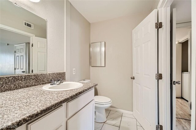 4955 Lindell Rd Unit 130, Las Vegas, NV 89118 - bathroom with toilet, vanity, marble look tile flooring, and baseboards
