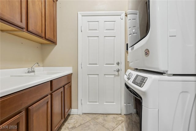 washroom featuring a sink, stacked washer and clothes dryer, and cabinet space
