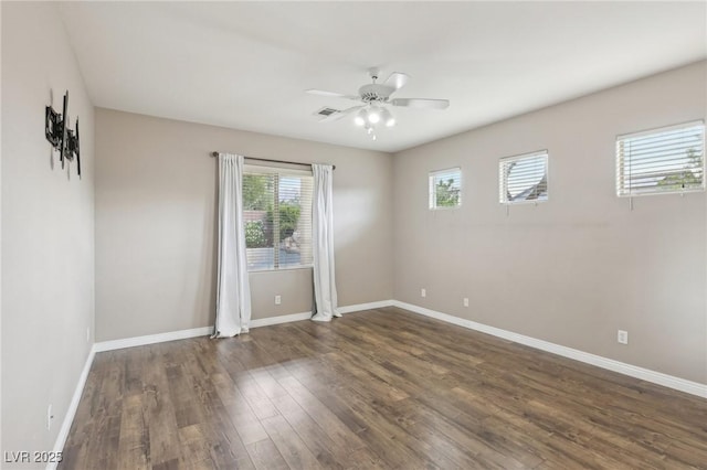 empty room with baseboards, wood finished floors, and a wealth of natural light