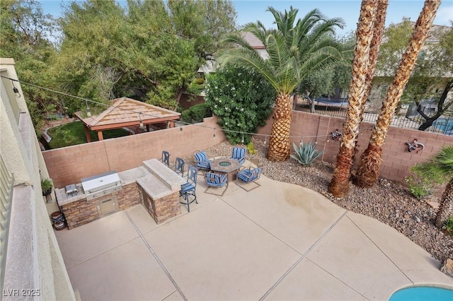 view of patio featuring a gazebo, a fenced backyard, and an outdoor kitchen