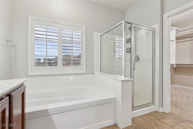 full bathroom featuring vanity, tile patterned floors, a bath, and a stall shower
