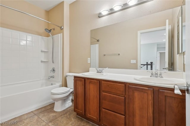full bath with double vanity, toilet, tile patterned floors, and a sink