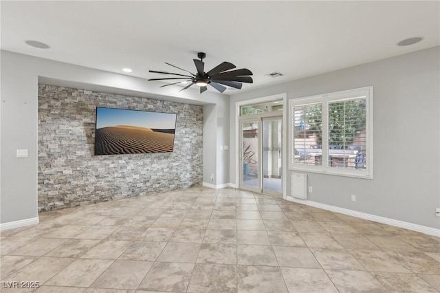 unfurnished living room featuring baseboards, ceiling fan, and visible vents
