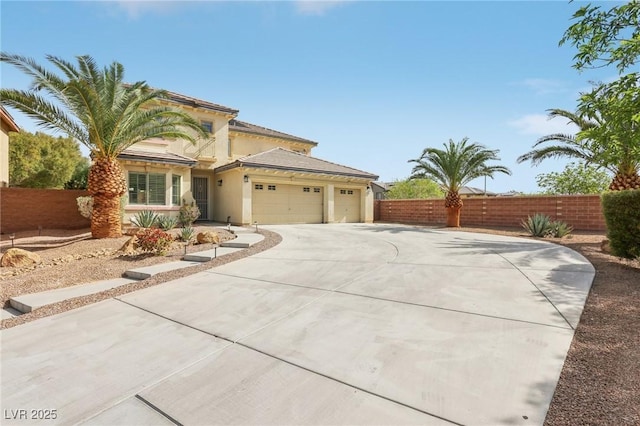 view of front facade featuring an attached garage, stucco siding, fence, and driveway