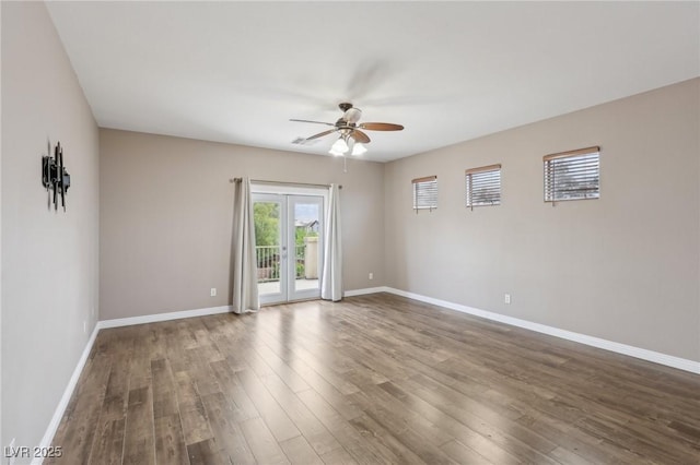 spare room featuring baseboards, ceiling fan, and wood finished floors