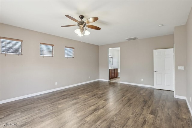 unfurnished room with visible vents, dark wood-type flooring, ceiling fan, and a healthy amount of sunlight
