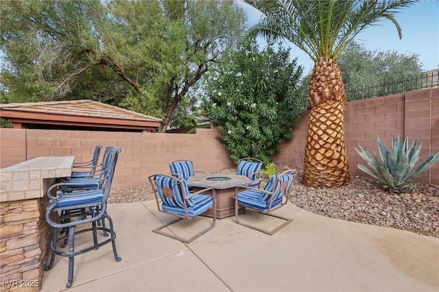 view of patio / terrace with an outdoor fire pit and fence