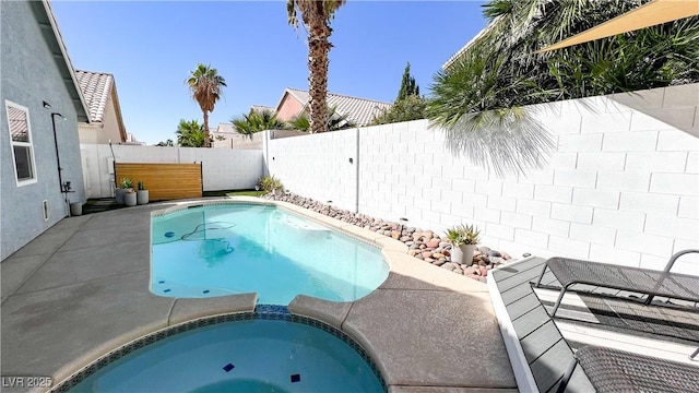 view of pool with a fenced backyard, a patio, and a pool with connected hot tub