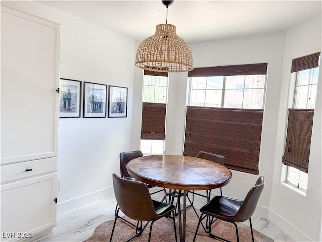 dining area featuring baseboards and marble finish floor