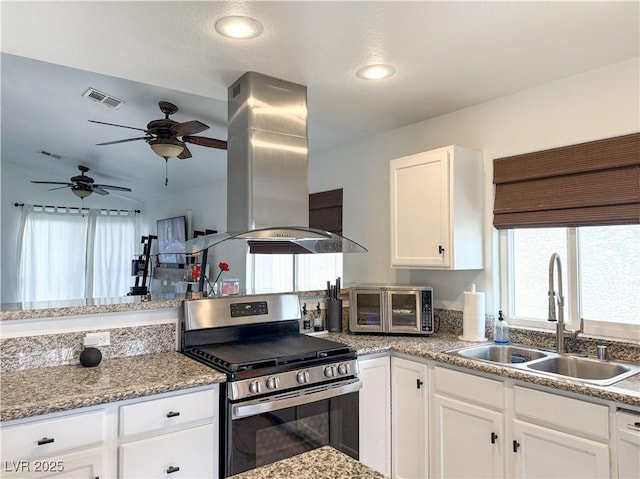 kitchen featuring a sink, stainless steel gas stove, island range hood, a toaster, and visible vents