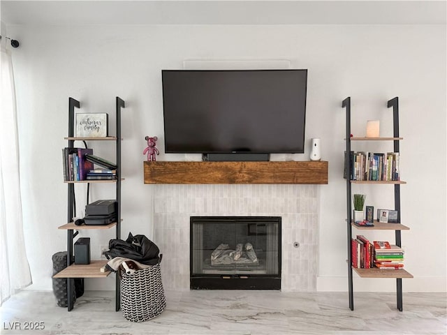 living area featuring marble finish floor and a tile fireplace