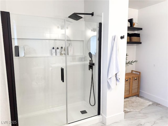 full bath with baseboards, marble finish floor, and a shower stall