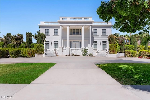 greek revival inspired property featuring a porch and a front lawn