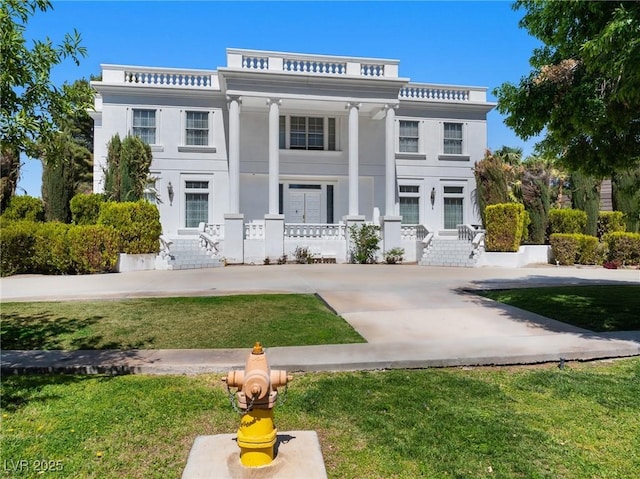 back of property featuring a porch, a yard, and stucco siding