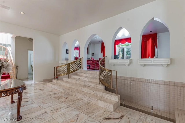 corridor featuring stairs and marble finish floor