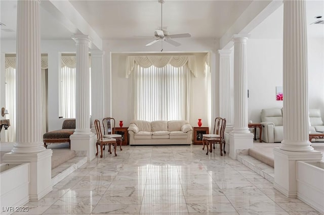 interior space featuring ceiling fan, decorative columns, and marble finish floor