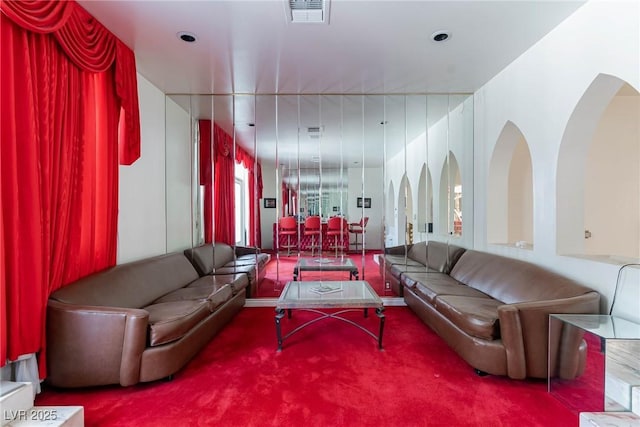 living area with visible vents and carpet flooring