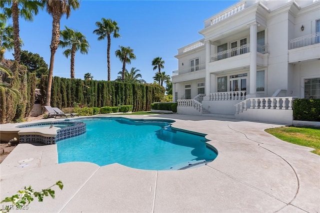 view of swimming pool with a patio and a pool with connected hot tub