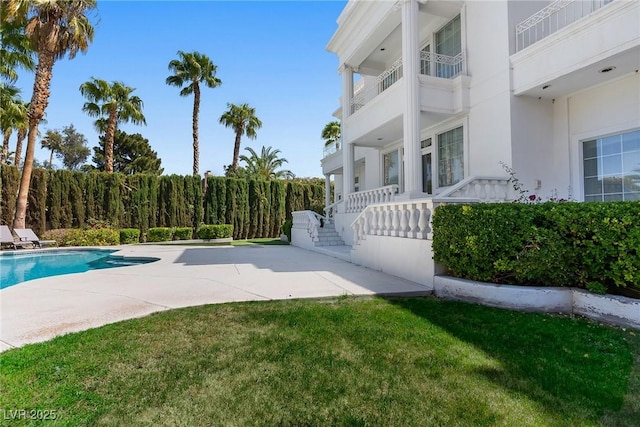 view of swimming pool featuring a fenced in pool, a lawn, and a patio