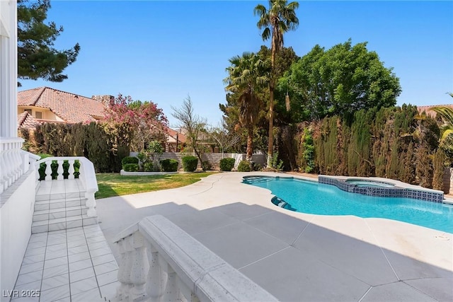 view of swimming pool with a pool with connected hot tub, a fenced backyard, and a patio area