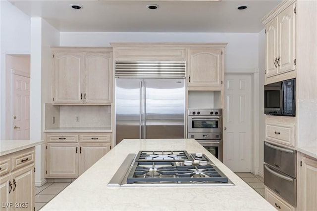 kitchen featuring light countertops, stainless steel appliances, light tile patterned flooring, and a warming drawer