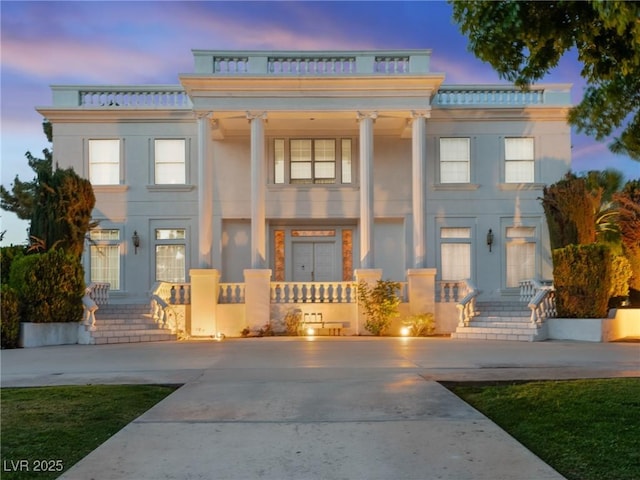 greek revival house with stucco siding and covered porch