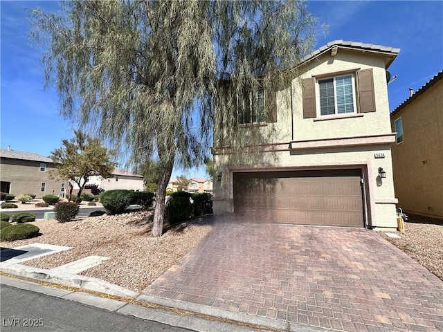 5634 Bishop Flowers St, Las Vegas, NV 89130 - view of front of house featuring stucco siding, an attached garage, and decorative driveway