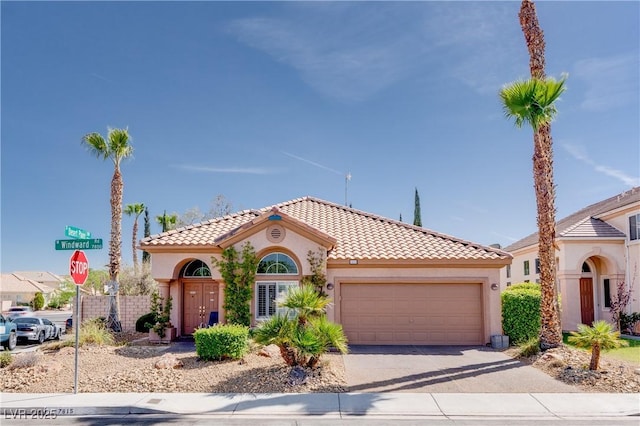 mediterranean / spanish home featuring a tiled roof, an attached garage, driveway, and stucco siding