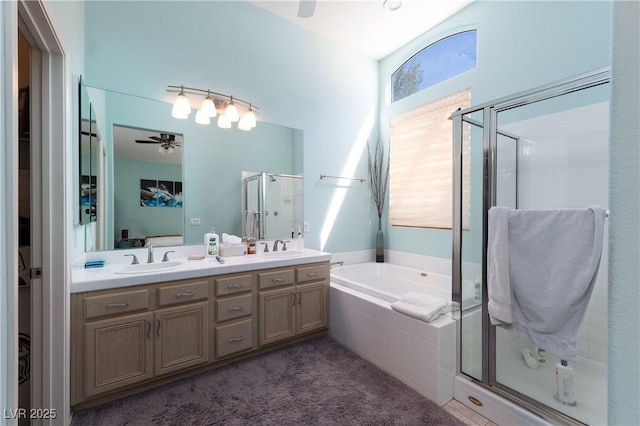 ensuite bathroom with a sink, ceiling fan, a stall shower, and a bath