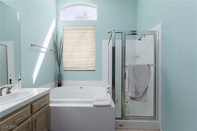 full bathroom with vanity, a shower stall, and a bath