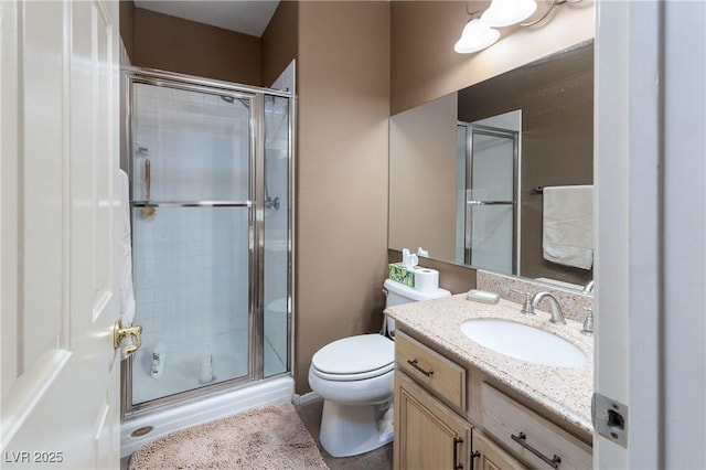 bathroom featuring vanity, tile patterned floors, a stall shower, and toilet