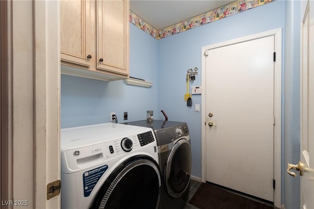 clothes washing area featuring dark tile patterned flooring, washing machine and dryer, and cabinet space
