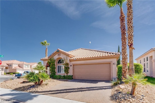 mediterranean / spanish-style home featuring a tiled roof, an attached garage, concrete driveway, and stucco siding