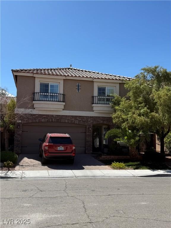9823 Belle Marie Ct, Las Vegas, NV 89141 - view of front facade with a tiled roof, an attached garage, stucco siding, and a balcony