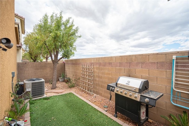 view of yard with central air condition unit and a fenced backyard